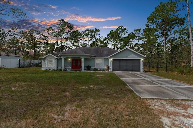 ranch-style house featuring a garage and a yard