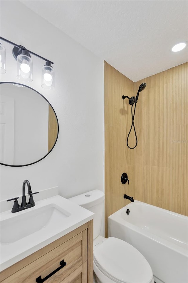 full bathroom featuring toilet, tiled shower / bath combo, and vanity