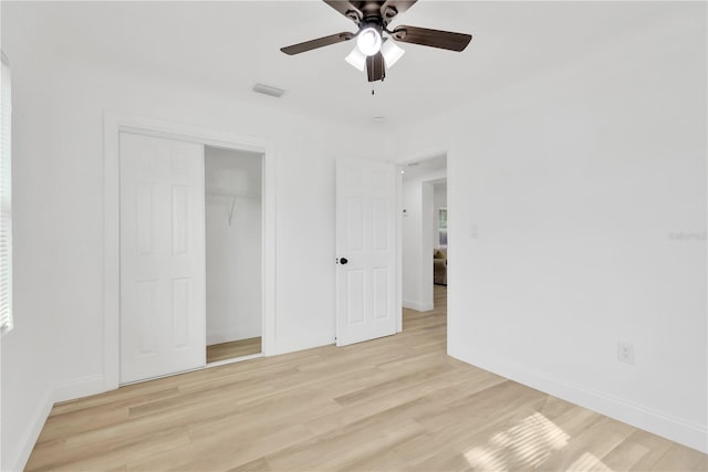 unfurnished bedroom featuring light wood-type flooring, ceiling fan, and a closet