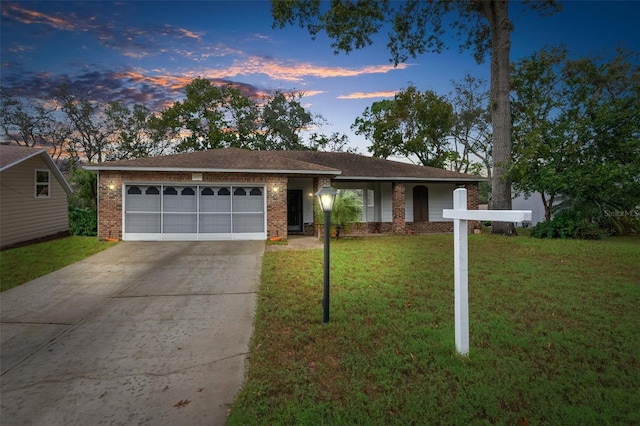 single story home featuring a garage and a yard