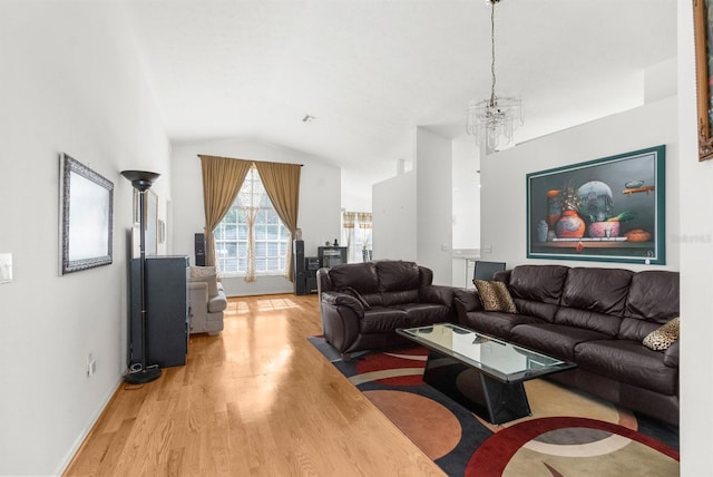 living room featuring a chandelier, light hardwood / wood-style flooring, and vaulted ceiling