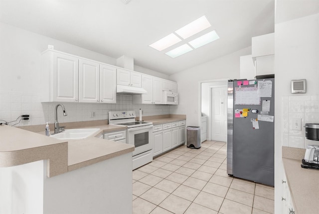 kitchen with vaulted ceiling with skylight, white appliances, white cabinetry, and sink