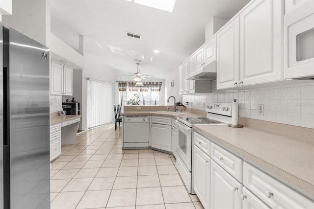 kitchen with white appliances, sink, light tile patterned flooring, and white cabinets