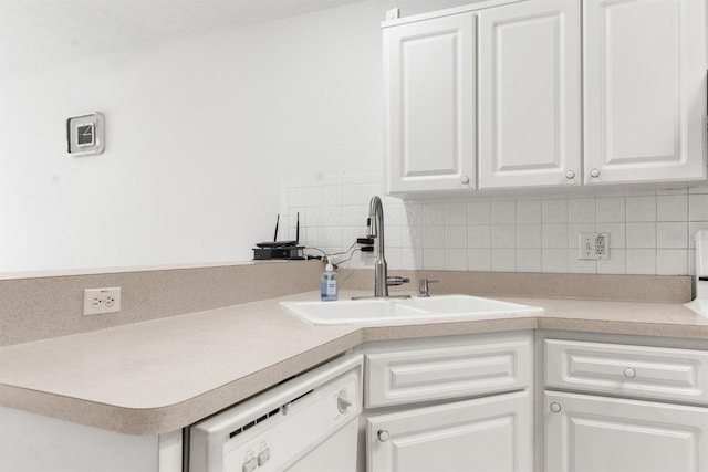 kitchen featuring white cabinets, white dishwasher, sink, and tasteful backsplash