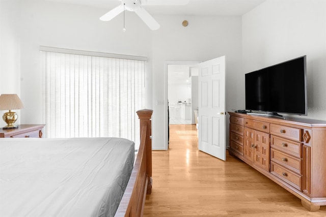 bedroom featuring light hardwood / wood-style floors, ceiling fan, and a high ceiling