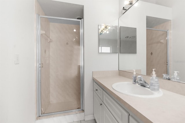 bathroom featuring a shower with shower door and vanity