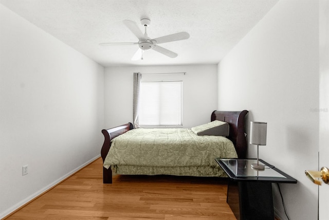 bedroom featuring hardwood / wood-style flooring, ceiling fan, and a textured ceiling