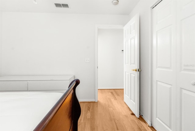 bedroom with light wood-type flooring and a closet