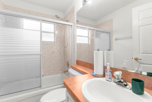 full bathroom featuring toilet, vanity, and shower / bath combination with glass door