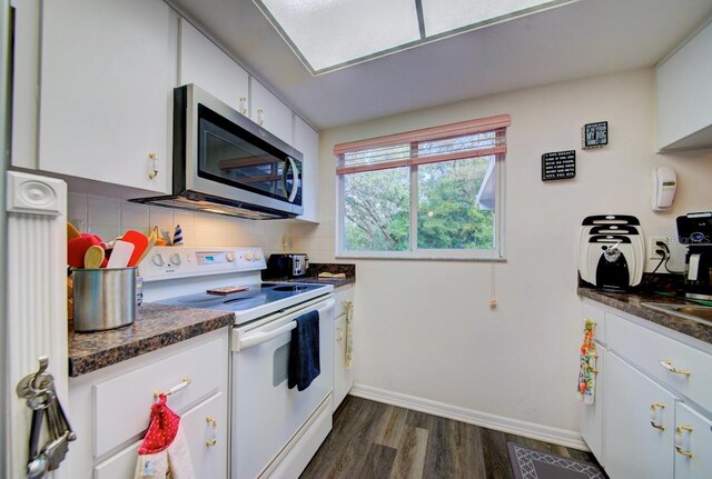 kitchen featuring tasteful backsplash, white electric stove, dark hardwood / wood-style flooring, white cabinets, and dark stone countertops