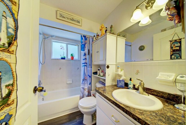 full bathroom with a textured ceiling, wood-type flooring, shower / tub combo with curtain, toilet, and decorative backsplash