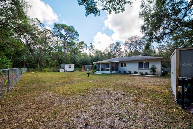 view of yard featuring a storage unit and a sunroom