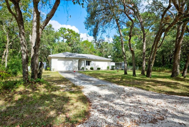 single story home featuring a garage and a front yard