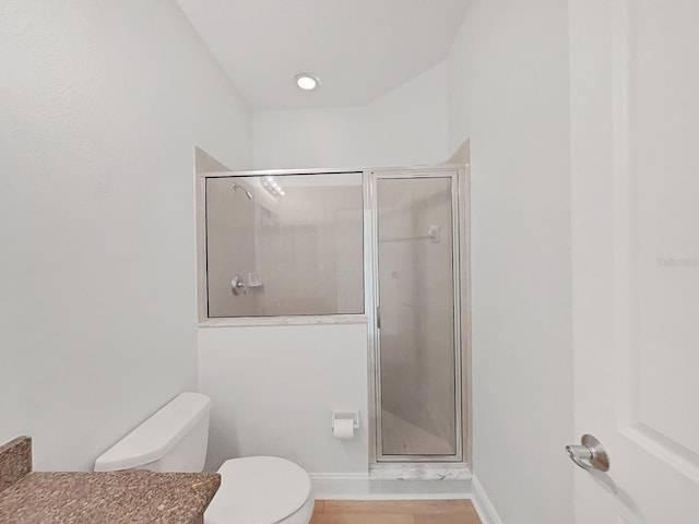 bathroom with a shower with door and toilet