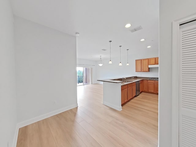 kitchen with light hardwood / wood-style floors, kitchen peninsula, sink, stainless steel dishwasher, and pendant lighting