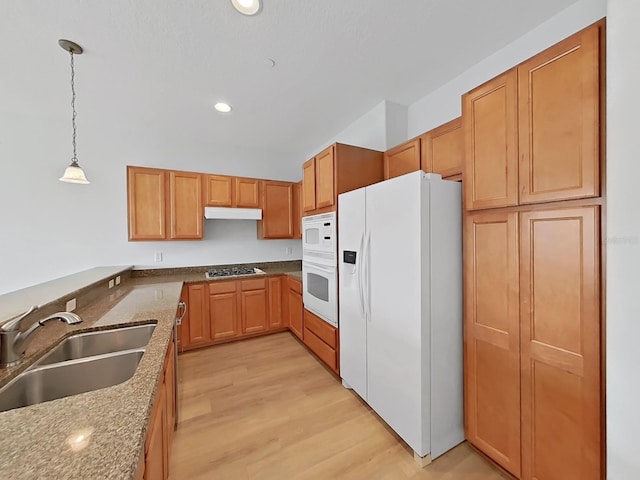 kitchen featuring light hardwood / wood-style floors, sink, stone countertops, white appliances, and decorative light fixtures