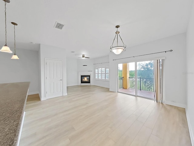 unfurnished living room with light wood-type flooring and ceiling fan