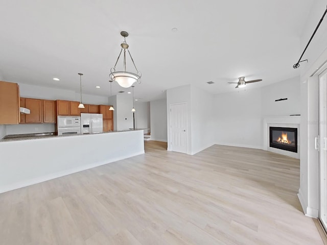 unfurnished living room featuring light hardwood / wood-style floors and ceiling fan