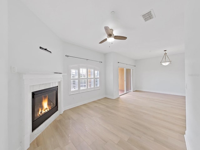 unfurnished living room with light hardwood / wood-style flooring and ceiling fan