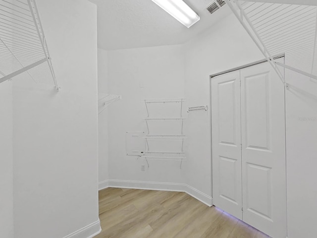 walk in closet featuring light hardwood / wood-style flooring