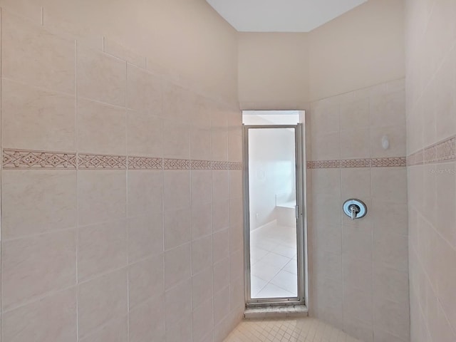 bathroom with tile patterned flooring and tiled shower