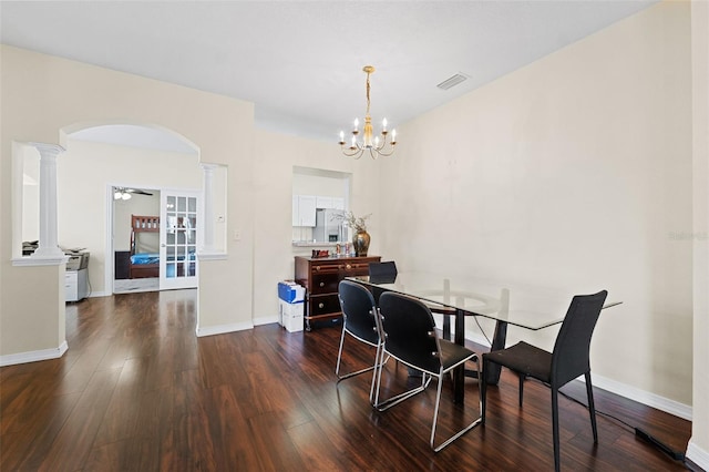 dining area with dark hardwood / wood-style floors, ceiling fan with notable chandelier, and ornate columns