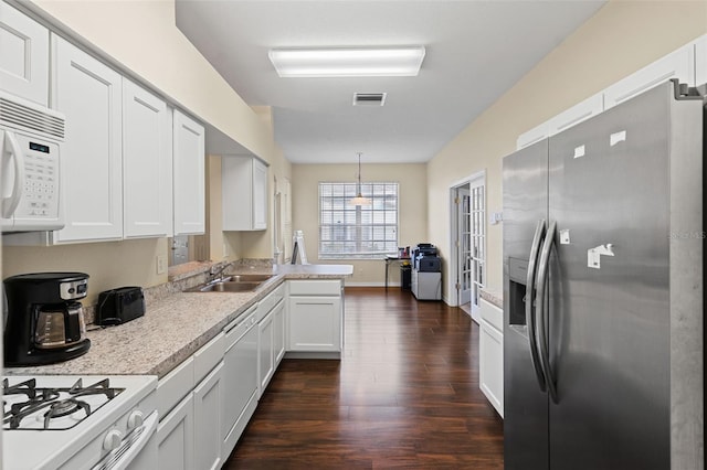 kitchen featuring sink, hanging light fixtures, dark hardwood / wood-style floors, white appliances, and white cabinets