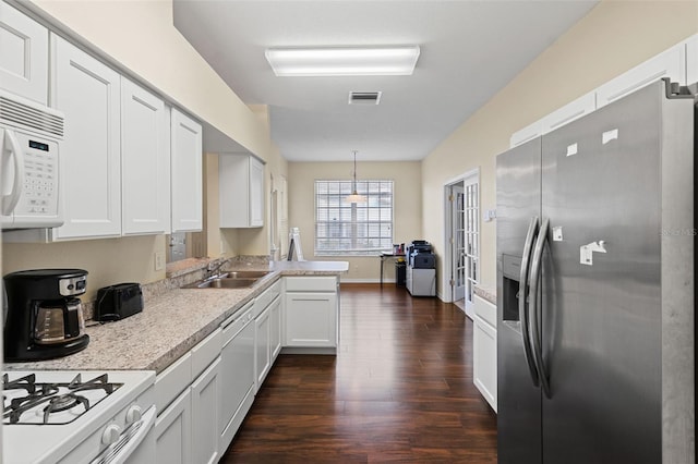 kitchen featuring white appliances, a sink, dark wood finished floors, light countertops, and white cabinetry
