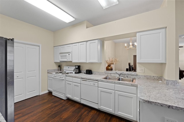 kitchen with pendant lighting, sink, white appliances, dark wood-type flooring, and white cabinetry