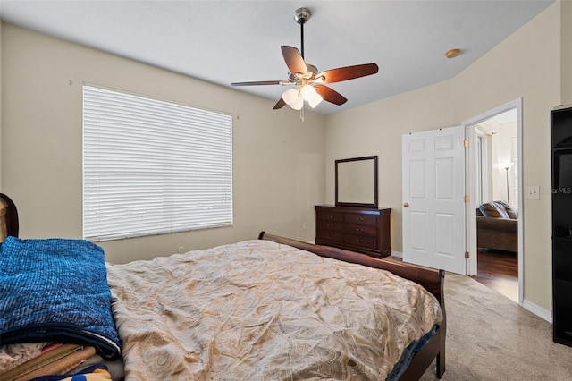 carpeted bedroom with ceiling fan and baseboards