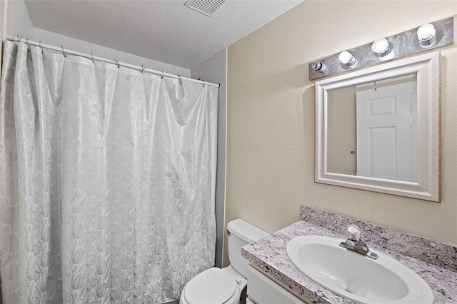 bathroom featuring visible vents, a textured wall, toilet, a textured ceiling, and vanity