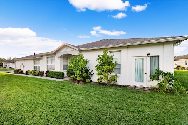 exterior space featuring a lawn and stucco siding