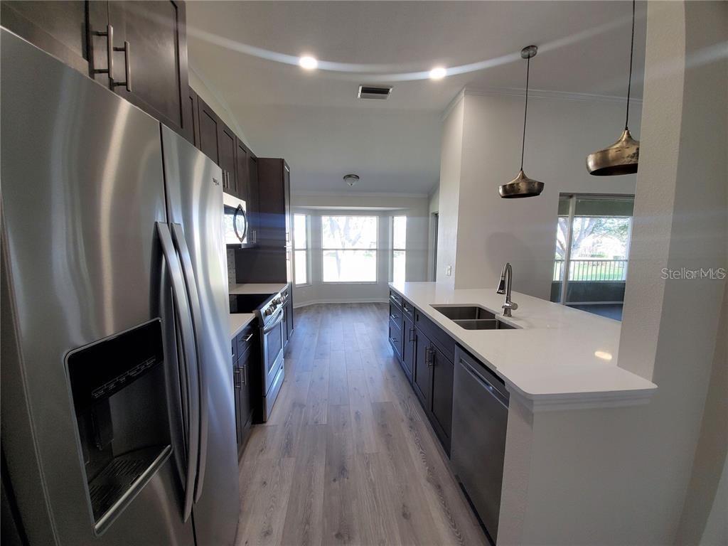 kitchen with appliances with stainless steel finishes, light wood-type flooring, plenty of natural light, and sink