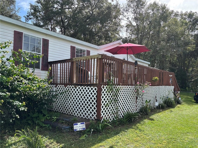 rear view of house featuring a lawn and a wooden deck