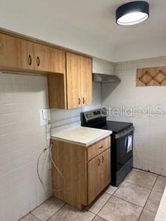 kitchen featuring black / electric stove and light tile patterned floors