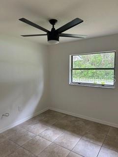 tiled empty room with ceiling fan