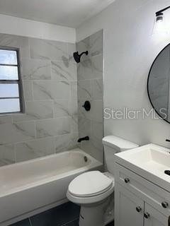 full bathroom with toilet, vanity, and tiled shower / bath