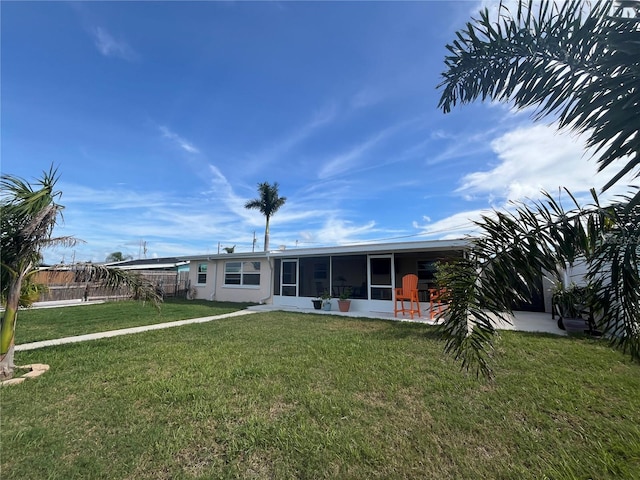 back of house with a yard and a sunroom