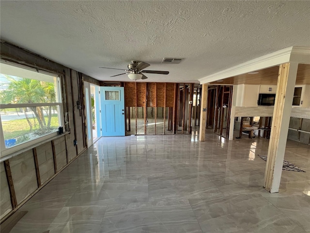 interior space with a textured ceiling and ceiling fan