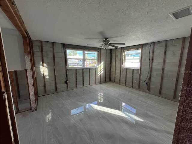 spare room featuring ceiling fan and a textured ceiling