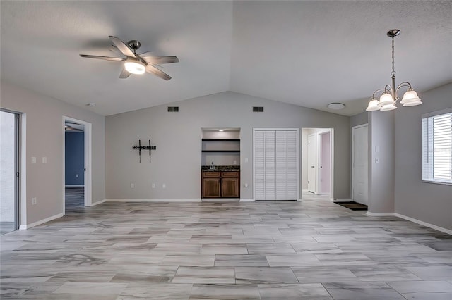 unfurnished living room with built in shelves, ceiling fan with notable chandelier, and lofted ceiling