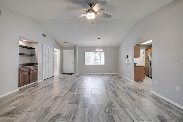 unfurnished living room with ceiling fan with notable chandelier, lofted ceiling, and light wood-type flooring