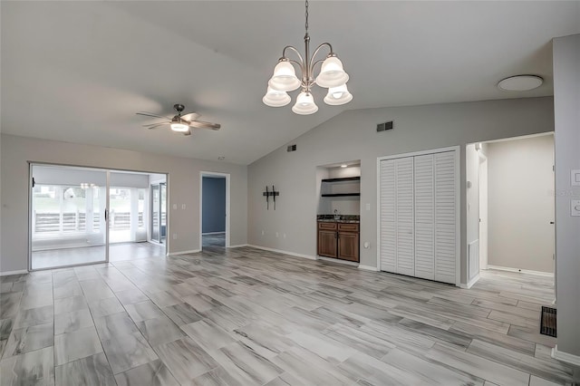 unfurnished living room with ceiling fan with notable chandelier, light hardwood / wood-style flooring, and vaulted ceiling