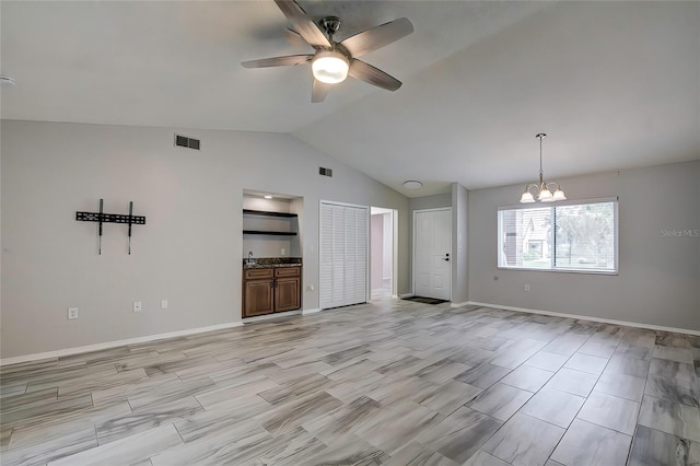 unfurnished living room with lofted ceiling and ceiling fan with notable chandelier