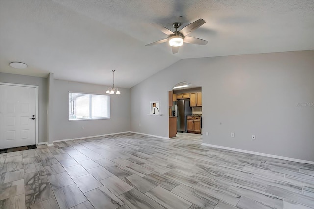 interior space with ceiling fan with notable chandelier and lofted ceiling