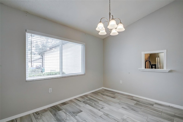 spare room with a chandelier and light hardwood / wood-style flooring