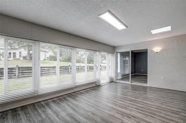 7499 Heather Walk, Weeki Wachee, FL 34613 - spare room with wood finished floors, a textured ceiling, a skylight, and a textured wall