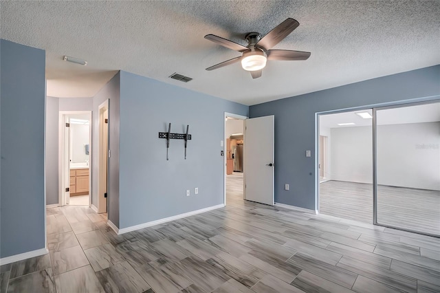 unfurnished bedroom featuring ceiling fan, a textured ceiling, a closet, and light wood-type flooring