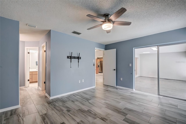 7499 Heather Walk, Weeki Wachee, FL 34613 - unfurnished bedroom featuring baseboards, a textured ceiling, a closet, ceiling fan, and wood finished floors