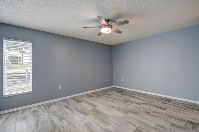 empty room with a textured ceiling and ceiling fan